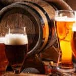 Beer barrel with beer glasses on table on wooden background