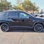 black 2025 Jeep Compass SUV parked at a Boucher Auto Group dealership