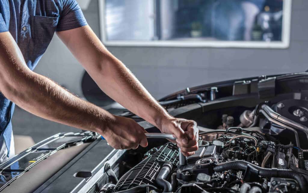 Service technician working on a Jeep engine.