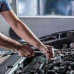 Service technician working on a Jeep engine.