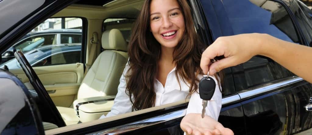 Smiling person being handed a car key