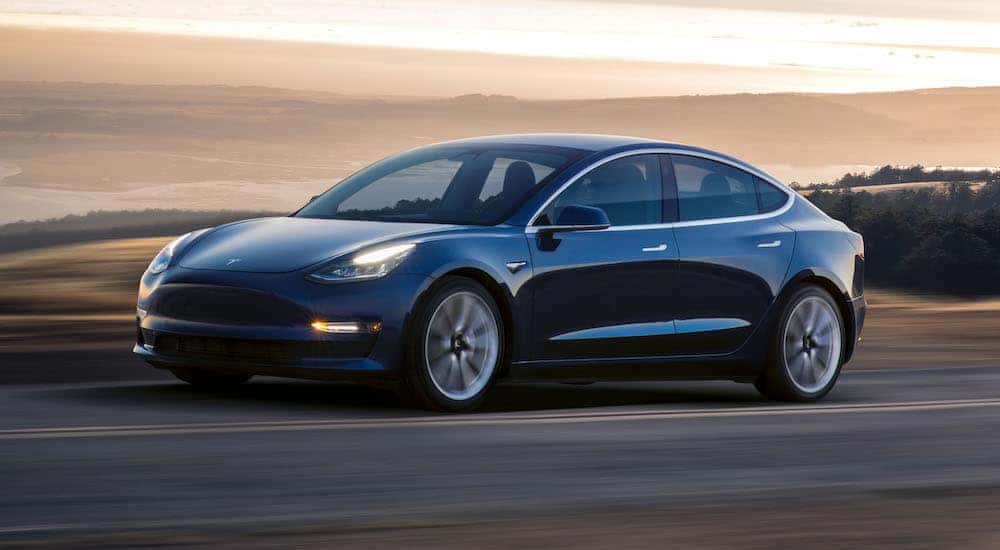 Black Tesla Model 3 driving