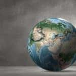 Person in a suit leaning against a globe