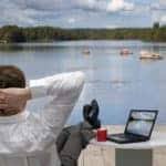 Person relaxing with feet on table near a lake