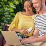Couple with a credit card and laptop online shopping