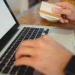 Close-up of male customer spending money on online shopping at cafe