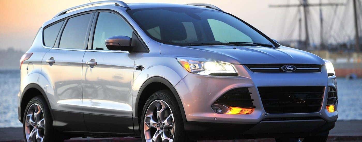 A silver Used 2013 Ford Escape at a marina in front of water and boats