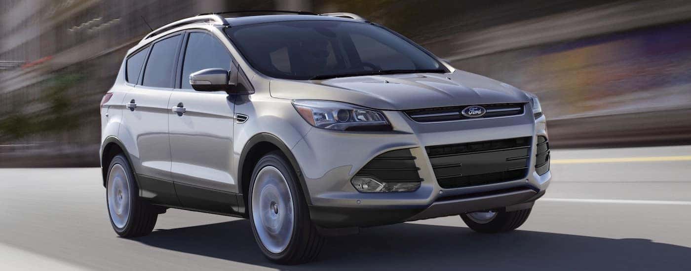 A silver 2014 Used Ford Escape driving on a city street