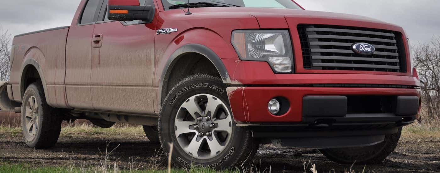 Red 2011 Used Ford F-150 on muddy terrain