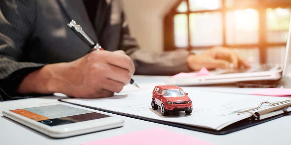 Man filling out auto loan paperwork at his desk 