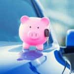 Closeup image new car with piggy bank, key on hood isolated