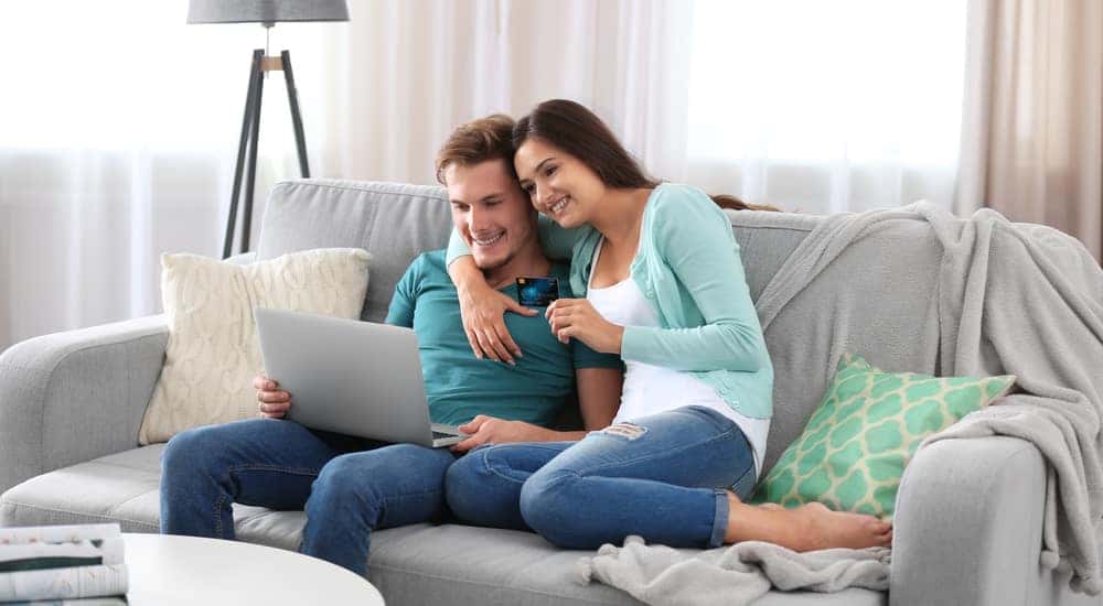 A couple shops for their next car from home at a online car dealer