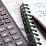 A calculator and checkbook for figuring our finances before shopping at a bad credit car dealership in Indianapolis