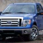 A blue 2009 Ford F-150 in a large dirt pit