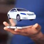 A virtual car is hovering over a man's hand holding his cell phone after looking up alternatives to Buy Here Pay Here in Indianapolis.