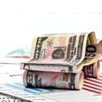 Money is folded to look like a car on top of financial documents.