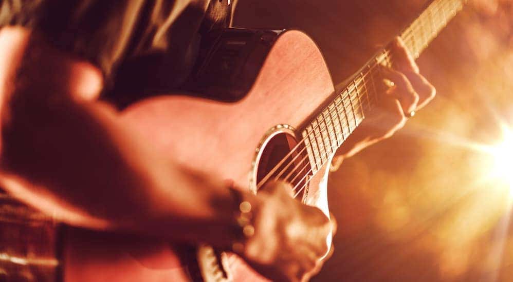 Close up of hands playing a guitar on stage
