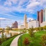 The Columbus, OH skyline is shown from a park.