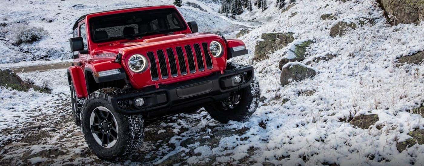 A red 2019 Jeep Wrangler is on a snowy trail.