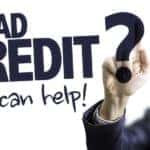 A blurry man is writing "Bad Credit? We Can Help!" on a clear board.