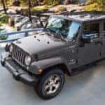 Grey 2017 Jeep Wrangler driving past a river after looking for used Jeeps for sale