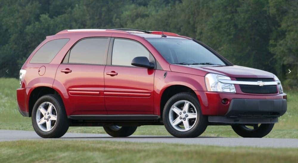 Een rode 2008 Chevy Equinox rijdt op een met gras begroeide weg in de buurt van Indianapolis, IN.