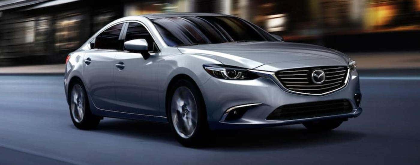 A silver used Mazda 6 is driving downtown after leaving a dealership for used cars in Columbus, Ohio.