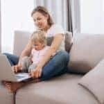 A mother and her toddler are on the couch as they try to buy a car online in Columbus, OH.