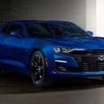 A blue 2019 Chevy Camaro SS from an online car dealership is parked in a dark garage.