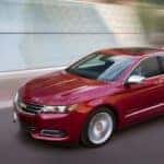 A red 2018 Chevy Impala is driving on a street near Indianapolis, IN.