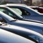 A row of used cars for sale in Louisville, KY, are shown on a lot.