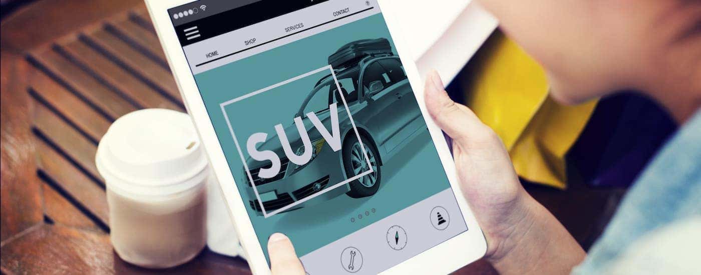 Someone is shopping for SUVs on a tablet.