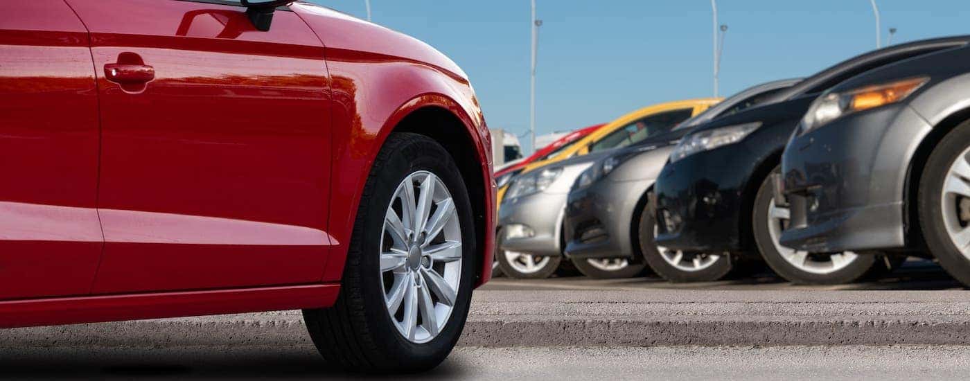 Rows of cars are shown on a dealership lot.