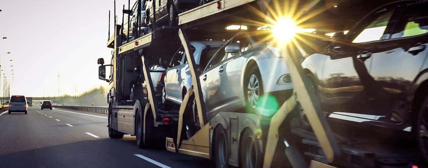 Cars are shown being delivered on a sunny day.