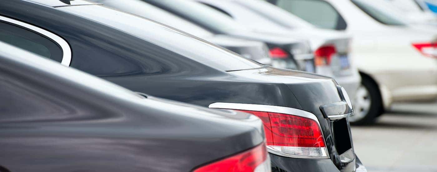 A close up shows the trunks of cars on a used car lot in Indianapolis.