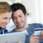 A couple is entering credit card information while learning how to buy a car online.
