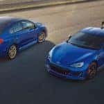 A blue 2018 Subaru WRX STI Type RA is parked next to a BRZ tS on tarmac.