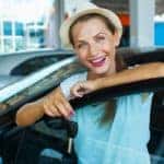 A woman is holding a set of keys at after looking at used cars for sale in Louisville.