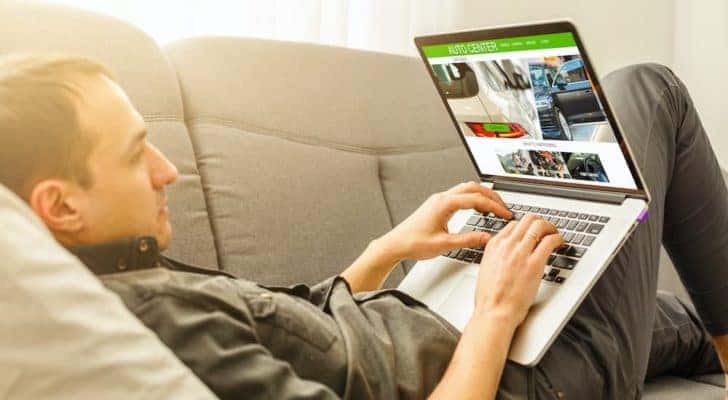 A person is laying on their couch looking for Indianapolis online car sales.