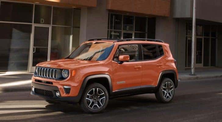 An orange 2020 Jeep Renegade is shown parked on a city street.