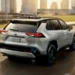 A grey 2020 Toyota RAV4 is shown from the rear driving on an open road after leaving a Grove City online car dealer.