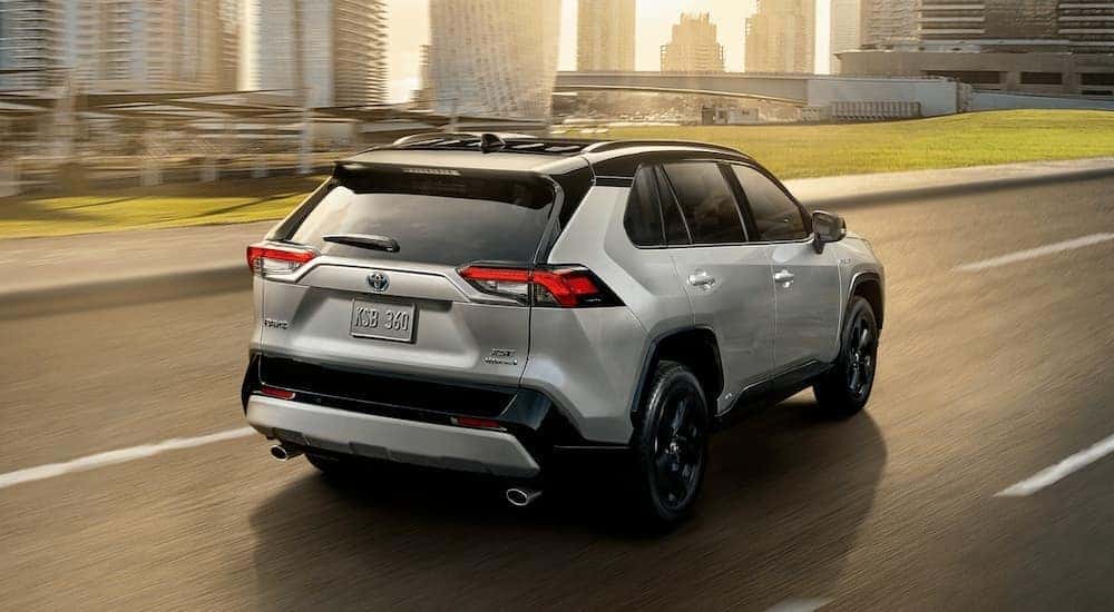 A grey 2020 Toyota RAV4 is shown from the rear driving on an open road after leaving a Grove City online car dealer.