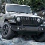 A white 2020 Jeep Wrangler Willys is shown parked on a pile of rocks after searching for "Kentucky online car sales."