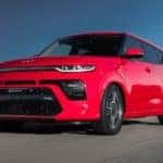 A red 2022 Kia Soul is shown driving on a road after visiting University City online car dealer.