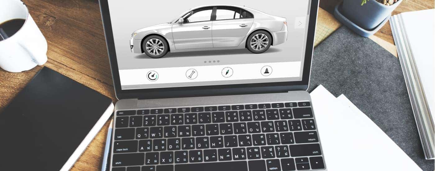 A laptop screen is shown looking at cars online.