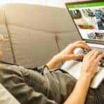 A person is shown online shopping on a laptop.