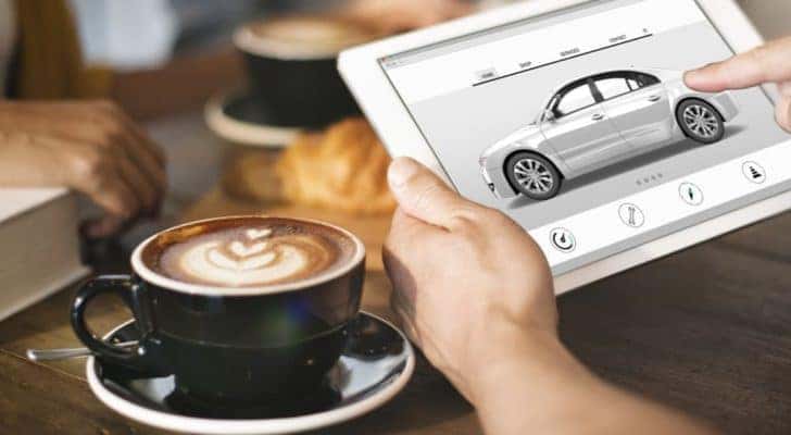 A person is shown viewing vehicles at a Zionsville online car dealer on a tablet.
