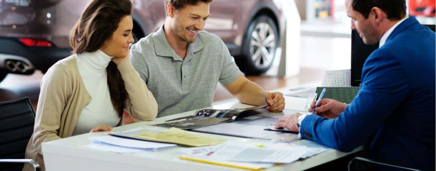 A salesman is shown speaking to a customer about vehicles.