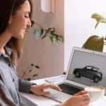 A woman is shown looking at cars at a Carmel online car dealership.