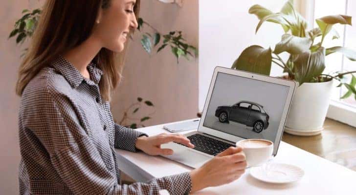 A woman is shown searching the website of a New Albany online car dealer.